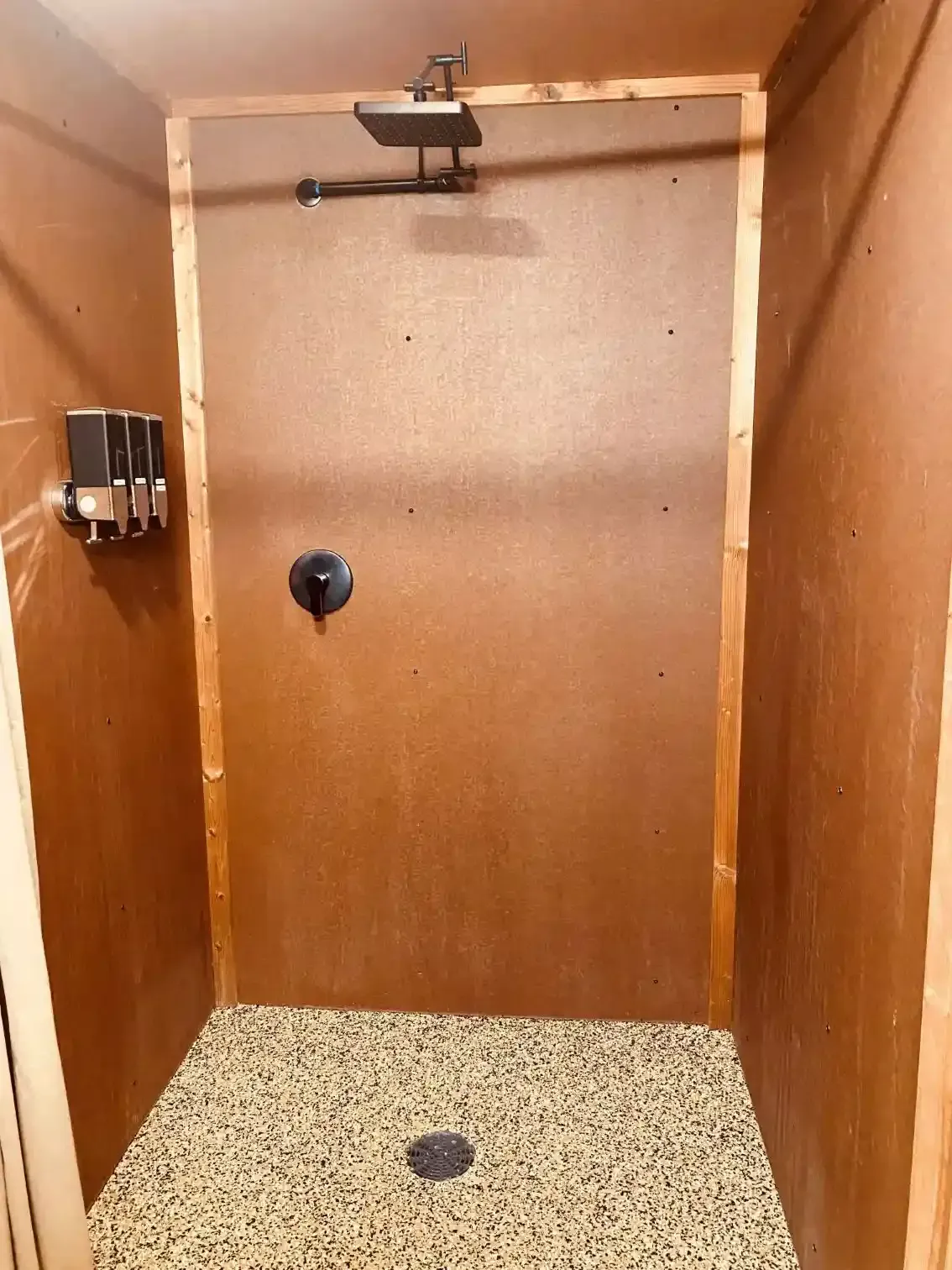 Large private walk-in shower at SOBO's Campground with rainfall showerhead, modern black fixtures, and spacious design for guest comfort.