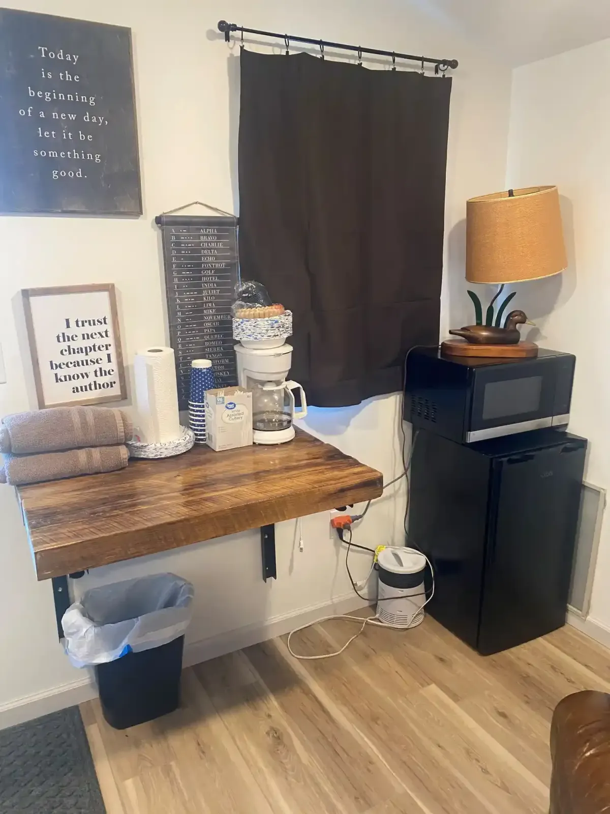 Coffee station inside a SOBO's Campground cabin with microwave, mini refrigerator, fresh towels, and rustic décor for guest convenience.