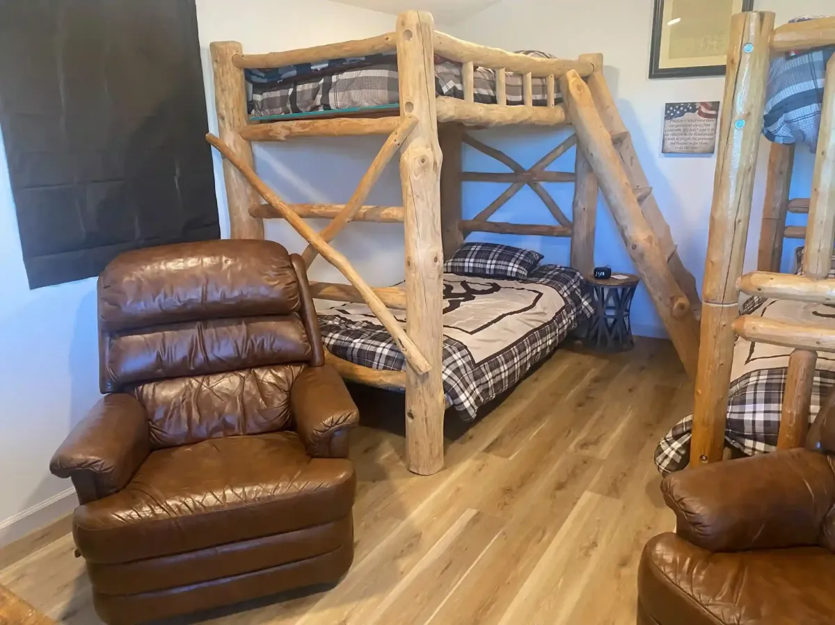 Spacious family cabin at SOBO's Campground featuring handcrafted log bunk beds, comfortable seating, and rustic lodge-style accommodations.