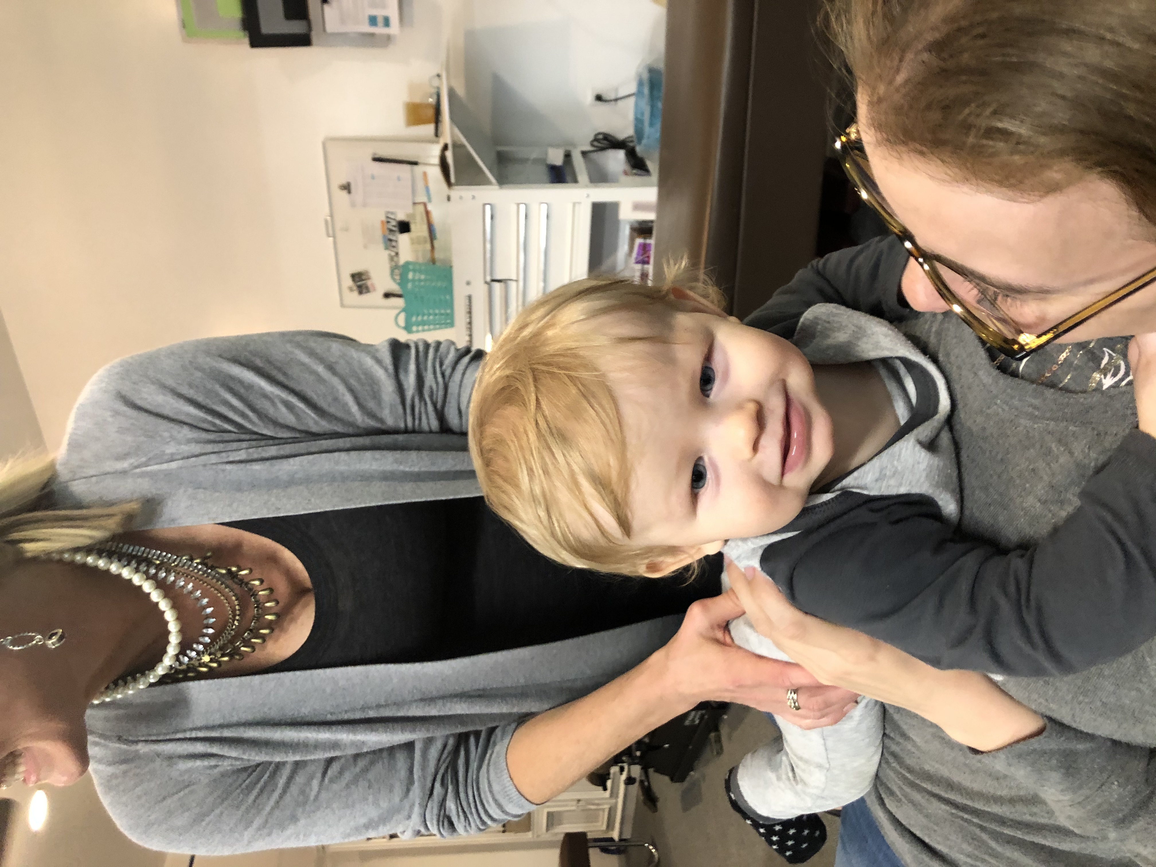 Dr. Carlson adjusting a happy toddler on his Mom's belly.