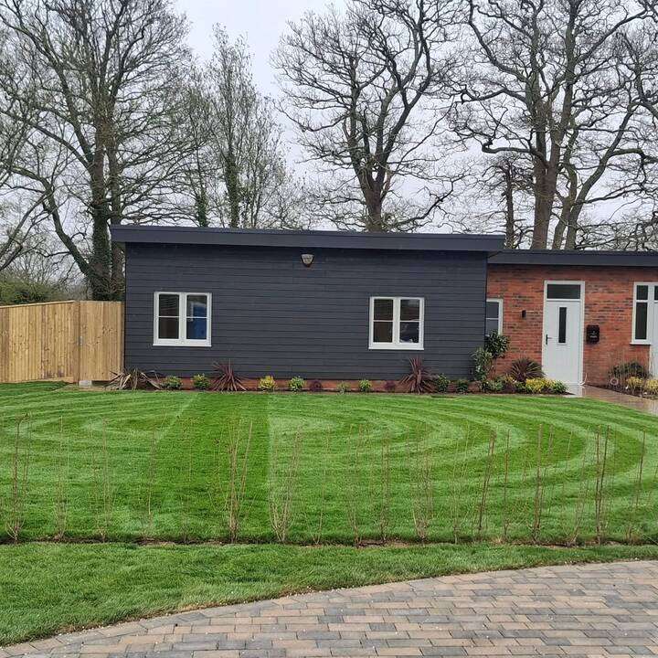 Premium front garden with striped lawn and ornamental stone urn feature in Gerrards Cross