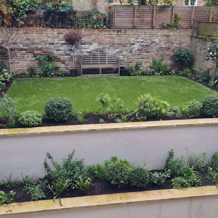 Before-and-after front garden transformation from overgrown gravel to landscaped pebble garden with topiary in Uxbridge