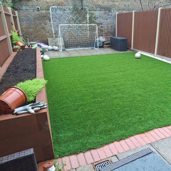 Block paved driveway alongside freshly turfed front lawn with sprinkler system in Ruislip