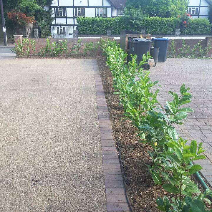 Front garden slate paving with timber bin store and stone pillar wall outside period home in Holland Park