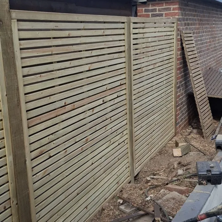 New slatted garden fence panels installed along a rear garden boundary in West London