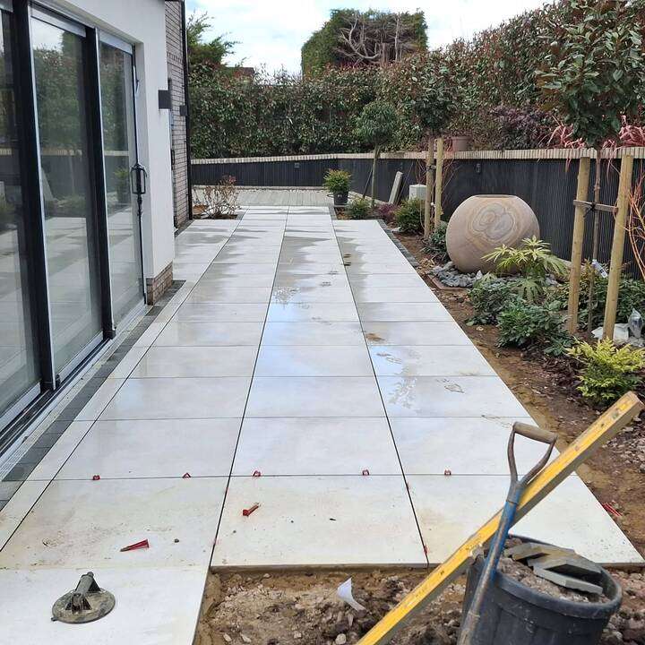 Indian sandstone slabs laid alongside red block paving area showing patio and driveway transition in Harrow