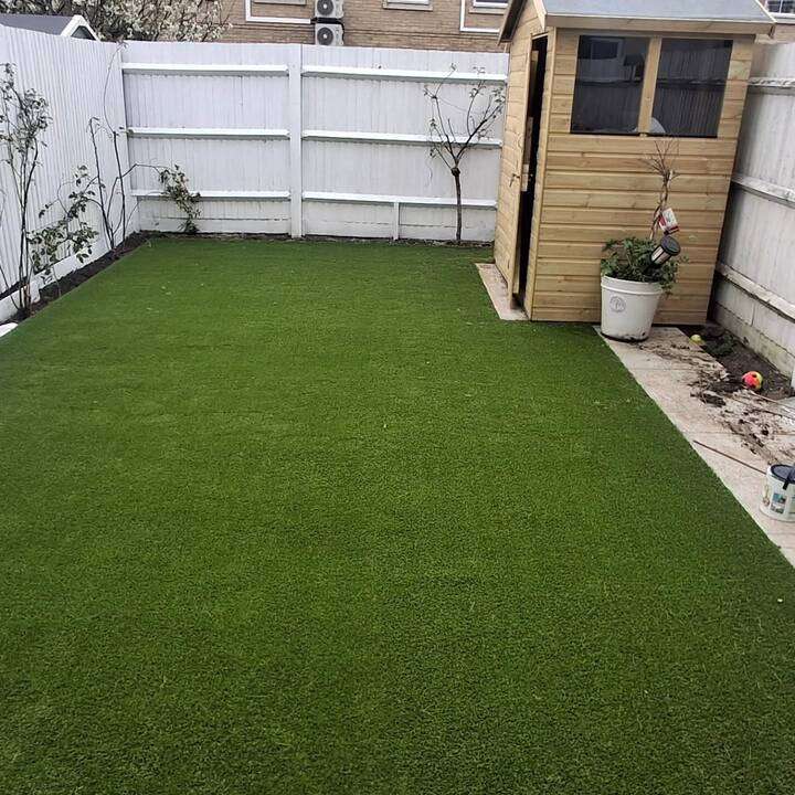 Artificial grass installation in family rear garden with goal post and brick edging in Harrow