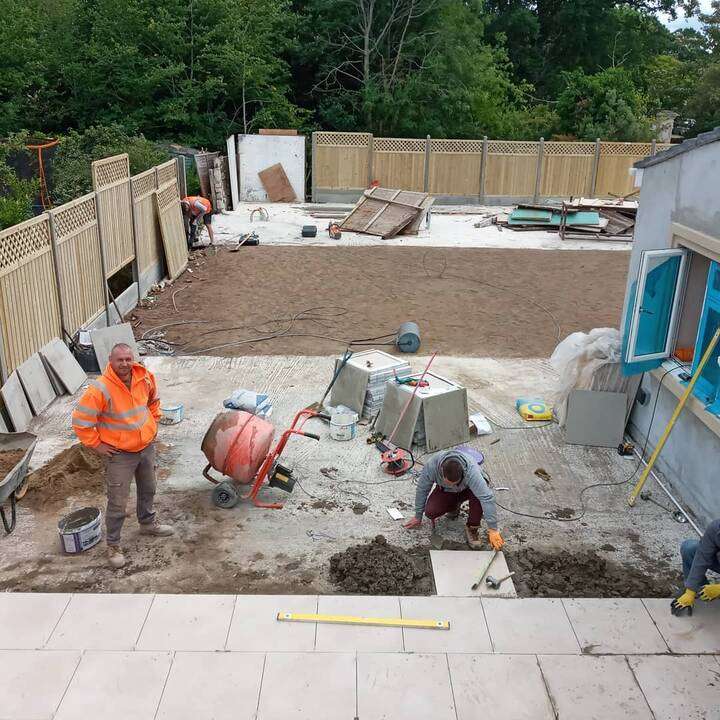 Artificial grass installation in rear garden with new white fencing and shed in Uxbridge
