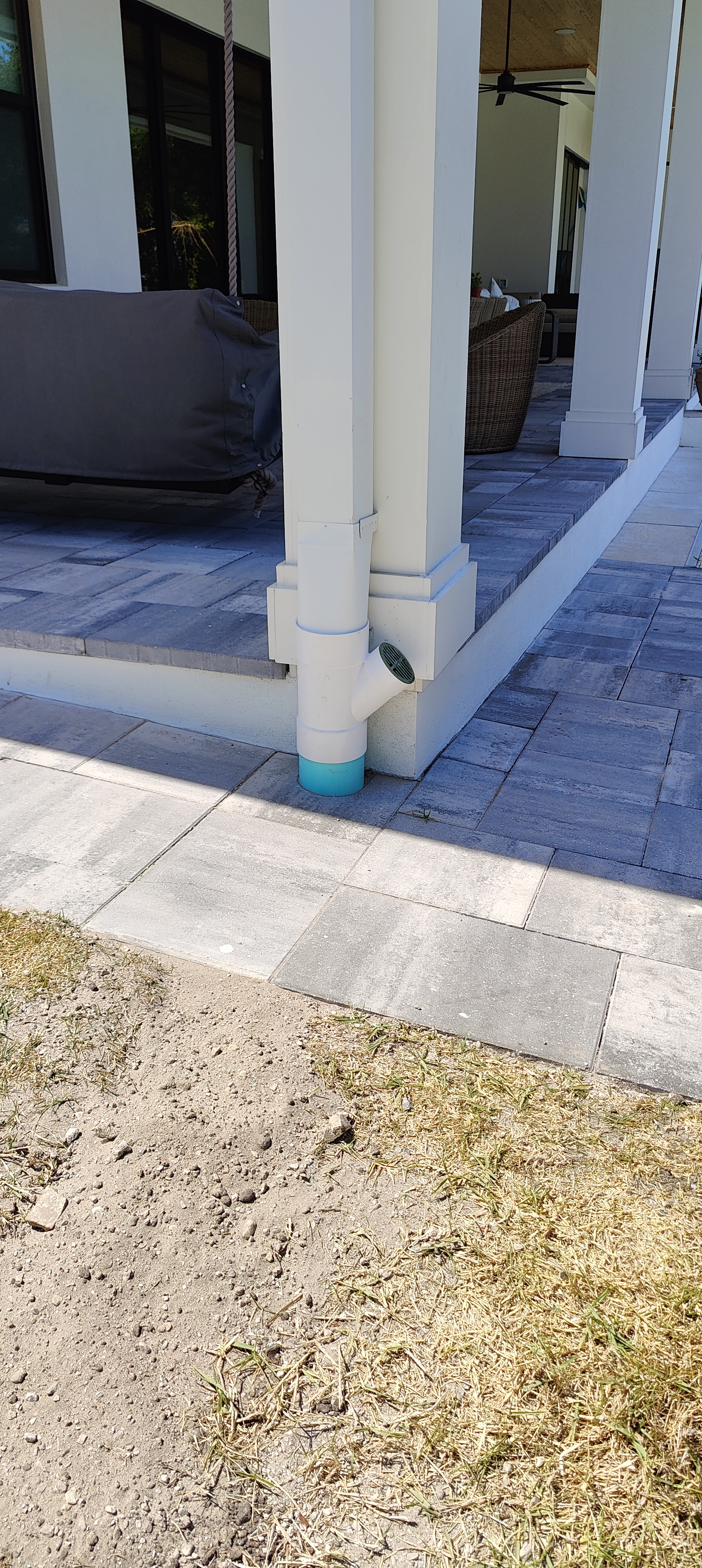 How We Route Downspouts Under Pavers the Right Way
