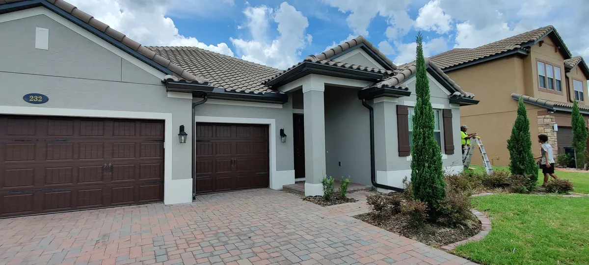 Tampa Bay tile-roof home with a paver driveway and Trufam seamless gutters
