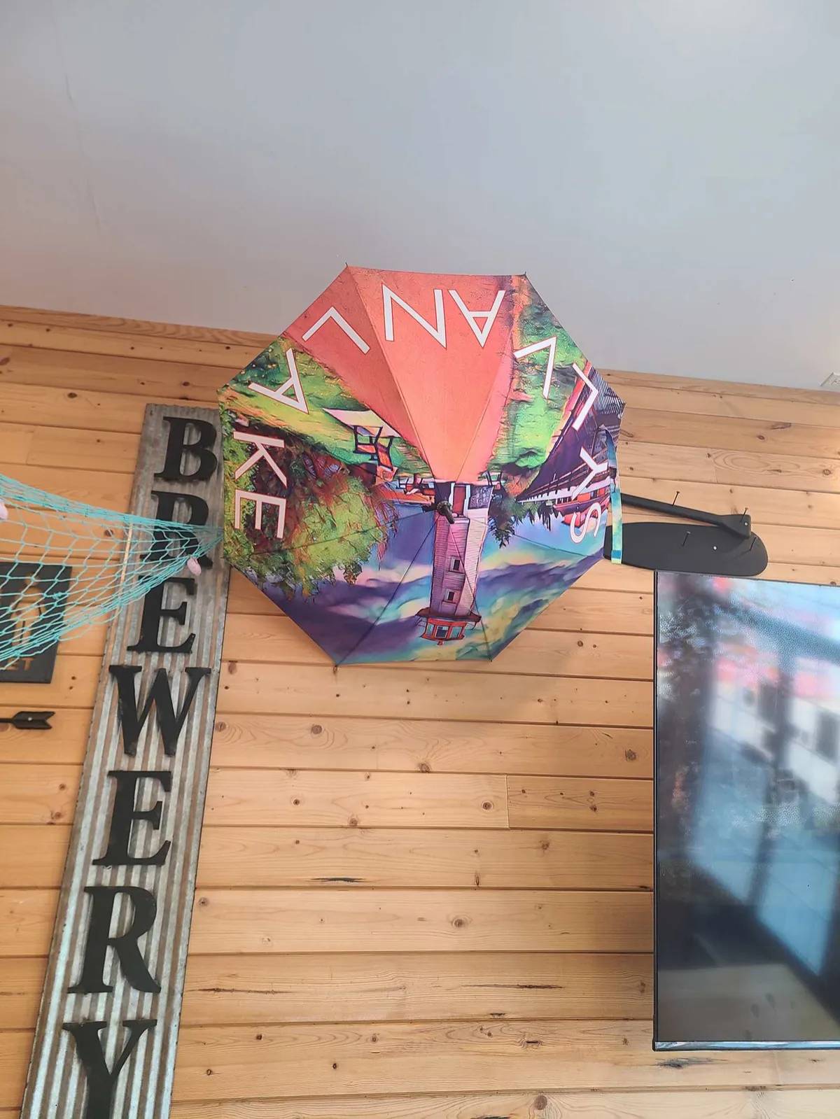A Sylvan Lake branded umbrella and wall signage inside 2nd Wind Brewery and Eatery