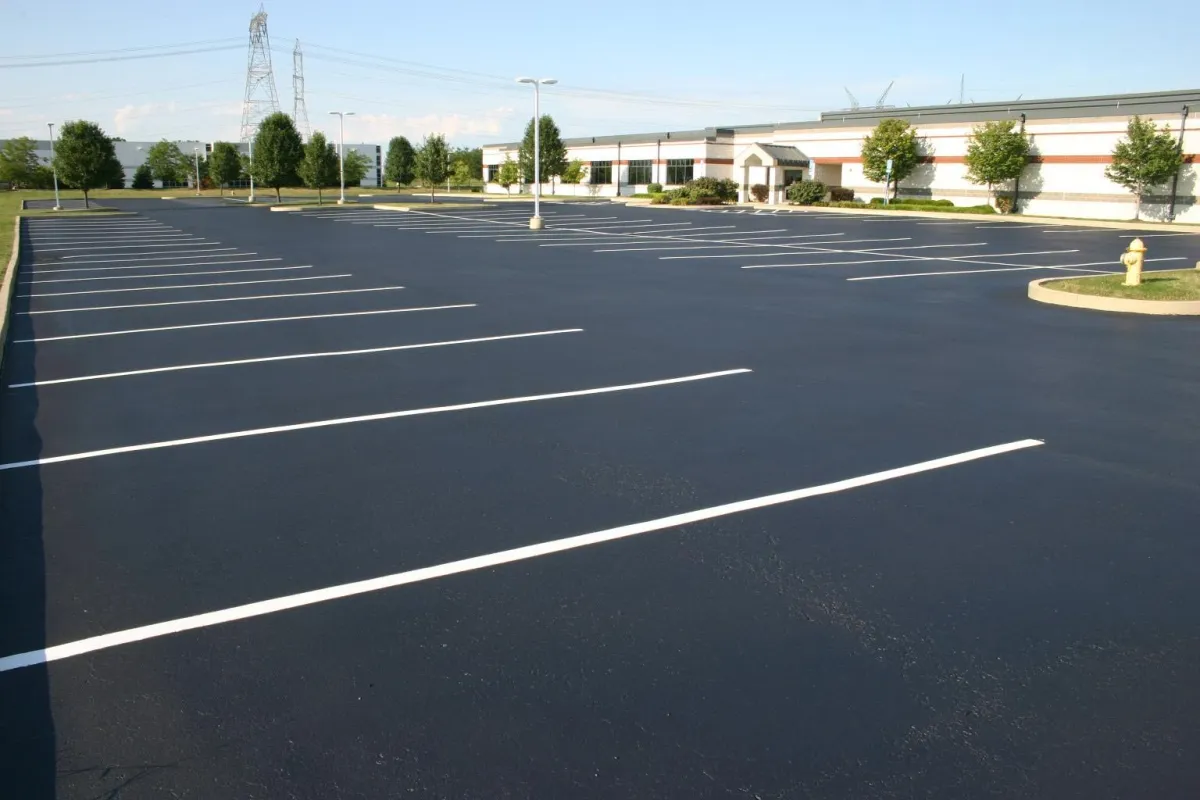 Our skilled asphalt paving crew finishing a spacious commercial parking lot with precision and care.