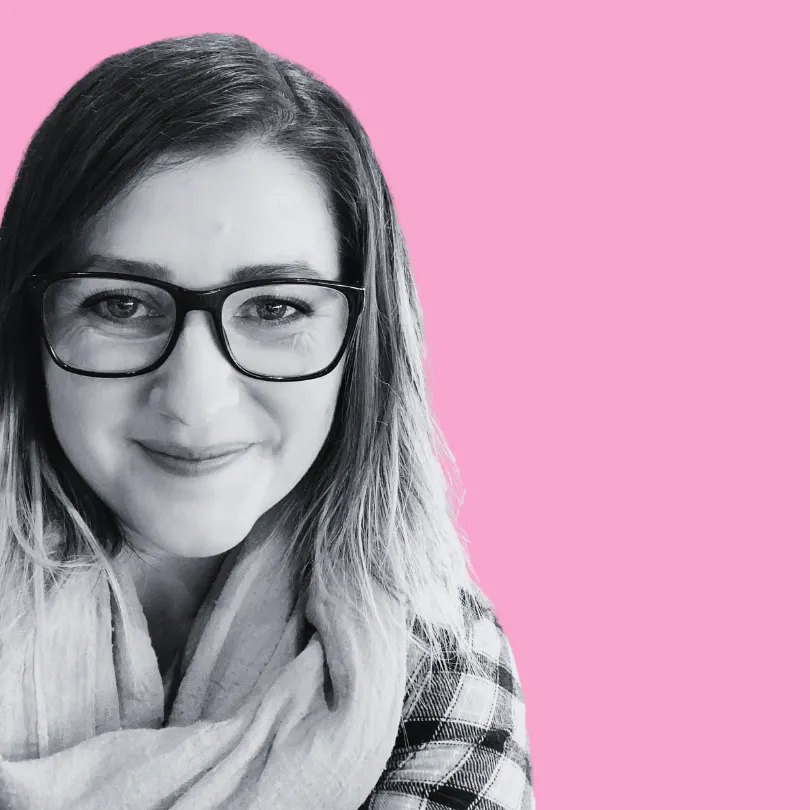 Shelly Terry, founder of Sheldon Social, in a black and white close-up photo wearing glasses and a scarf, displayed in a circular crop against a pink background — content strategist and visibility consultant helping founders and brands shape how they're understood online.