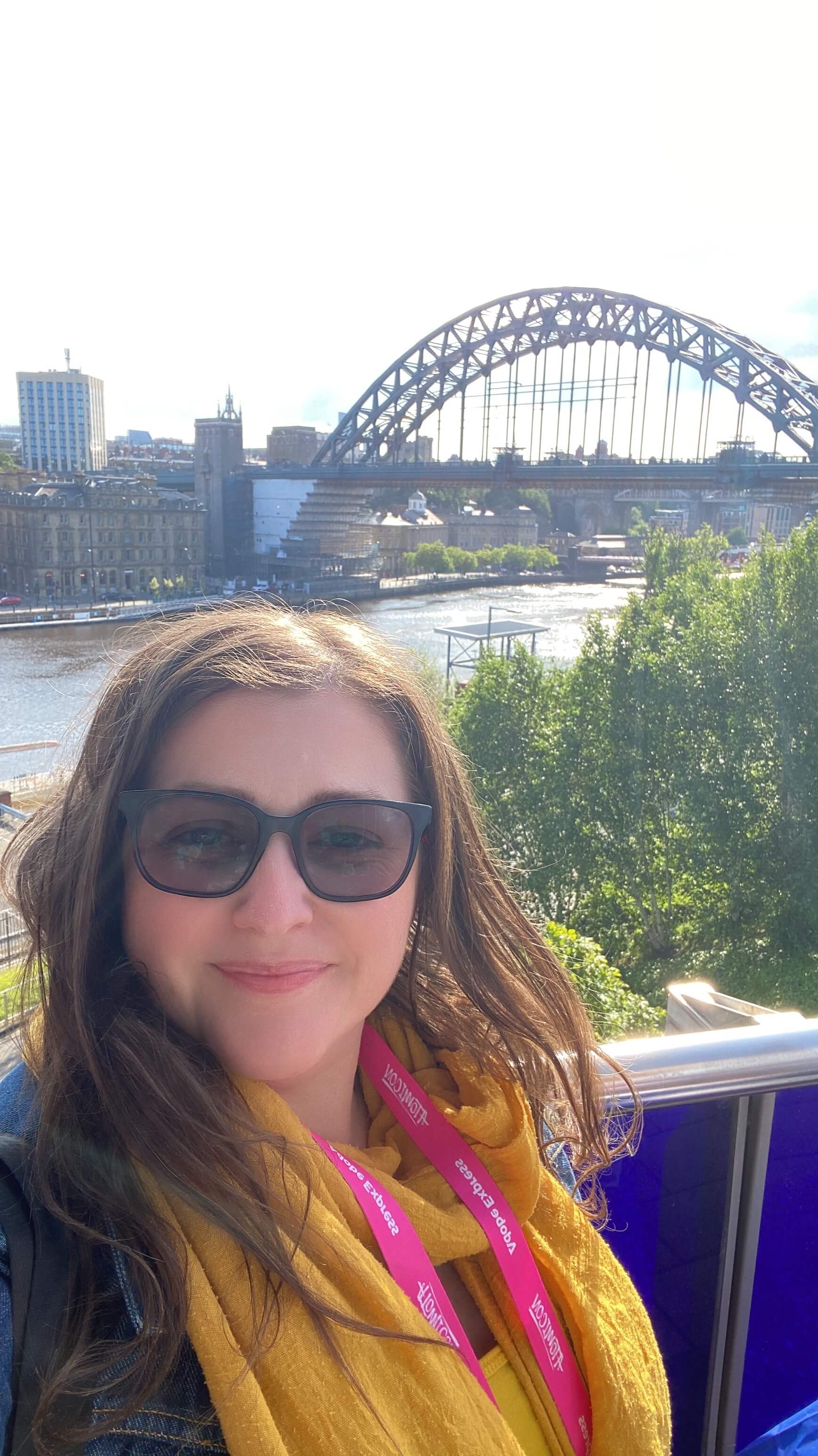 Shelly Terry, founder of Sheldon Social, smiling at the camera in front of the Tyne bridge.