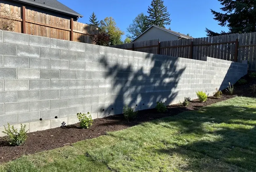 Concrete block retaining wall in a backyard on a sunny day in Ashland, Oregon