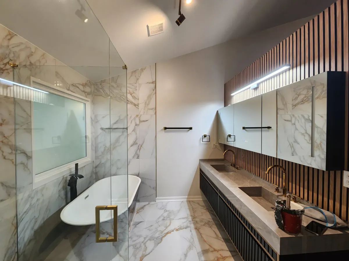 Slab walls and floor. Calacatta porcelain, veining continuous across the seams