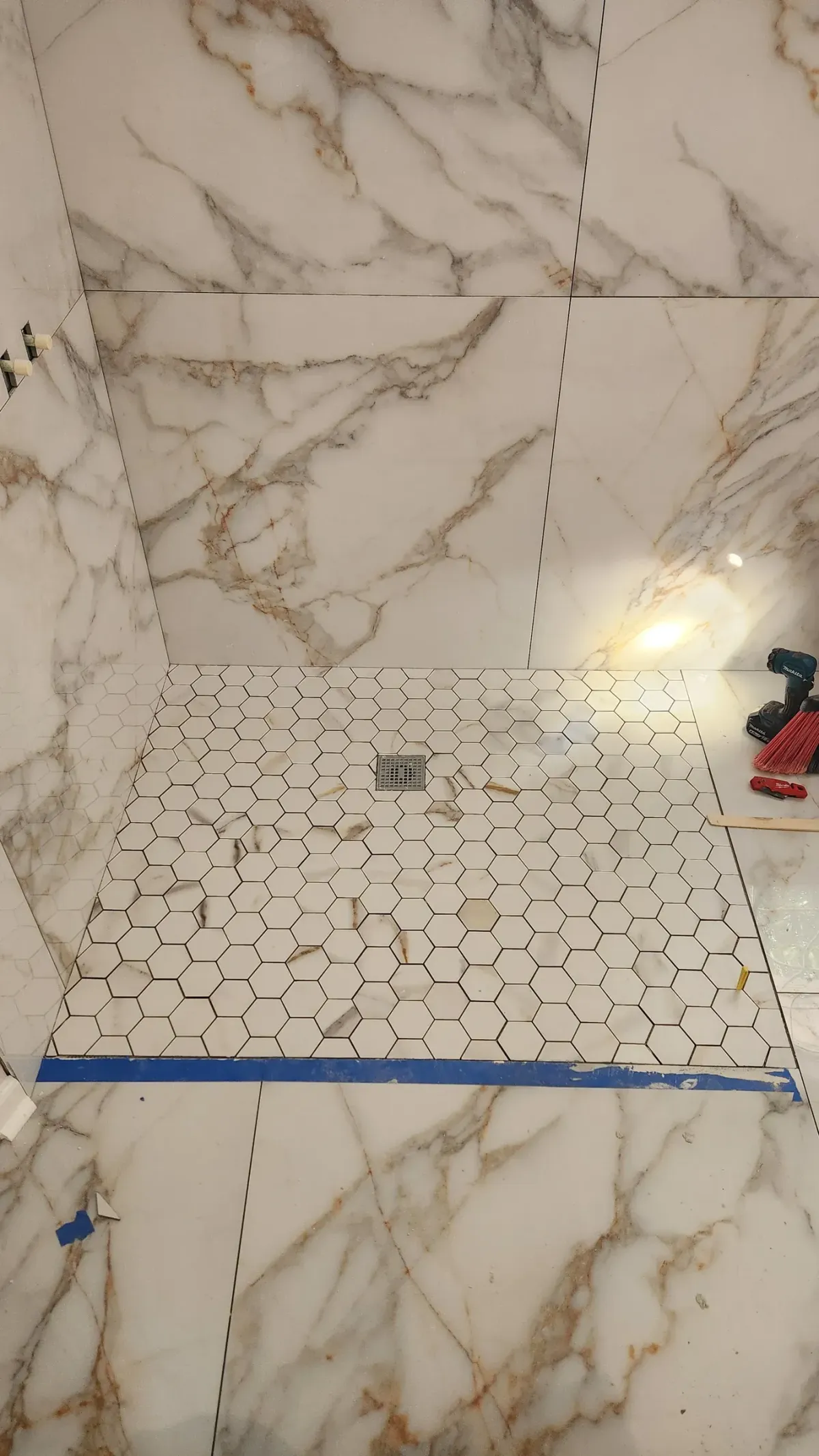 Hex mosaic pan. Set tight, cut clean at the curb, sloped properly to the drain