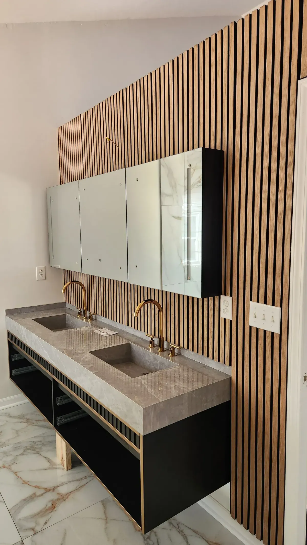 Slat wall and floating vanity. Custom carpentry built into the bathroom, not bought off a shelf