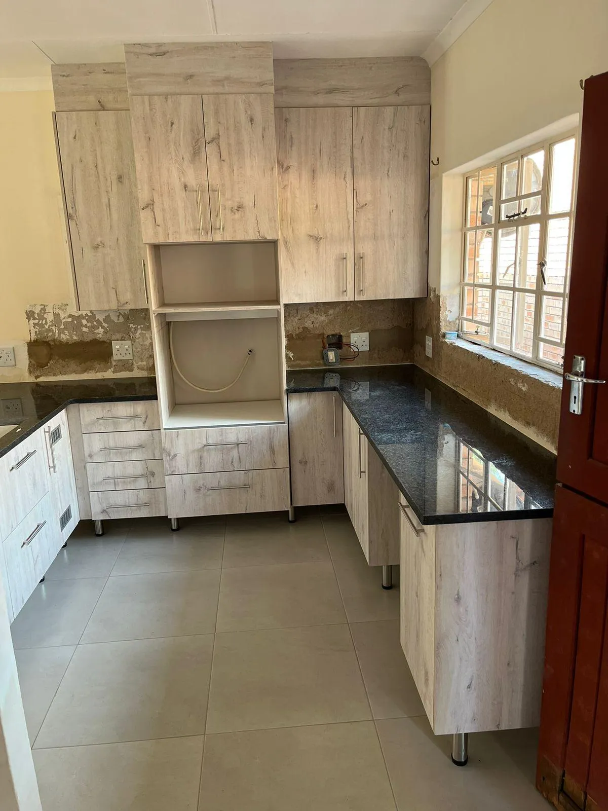 Kitchen units with built-in stove and microwave space and custom countertops.
