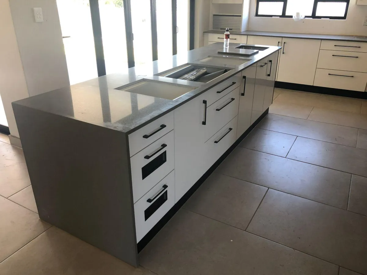 Gray kitchen cabinets with space for stove.