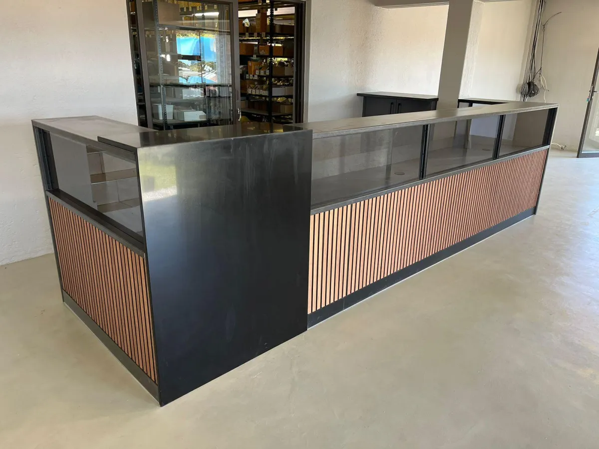 Glass-top shop counter with custom flat-panel finishes.