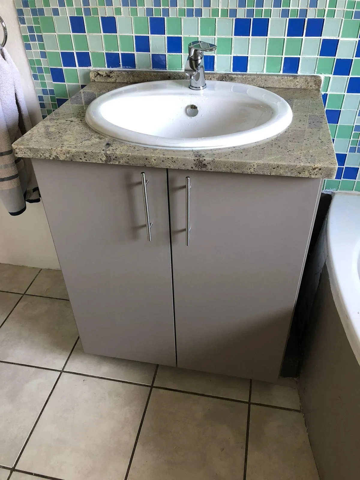 Spacious bathroom with floating vanity unit and quartz countertop.