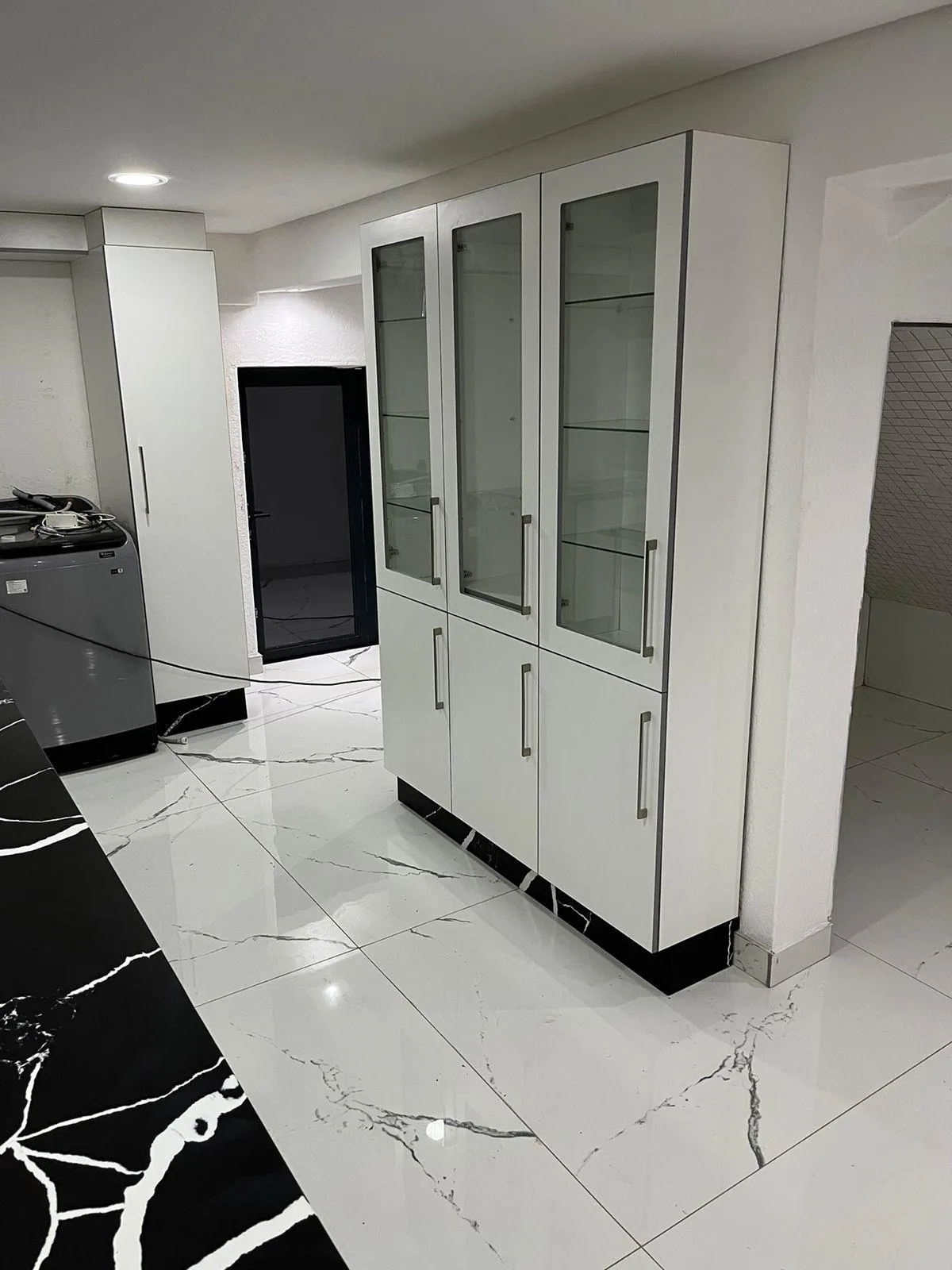 Black and white quartz countertop with white built-in cabinets, featuring a sleek and modern design.