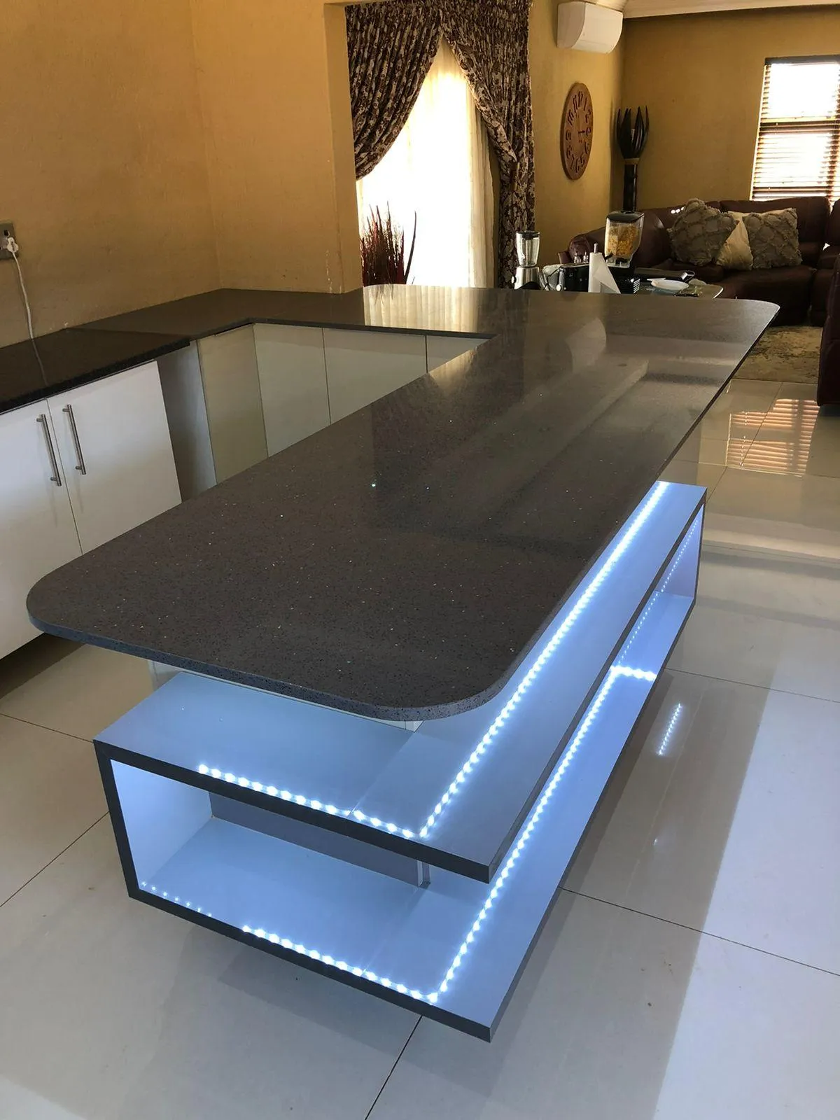 LED-lit kitchen cabinetry with two built-in shelving spaces.