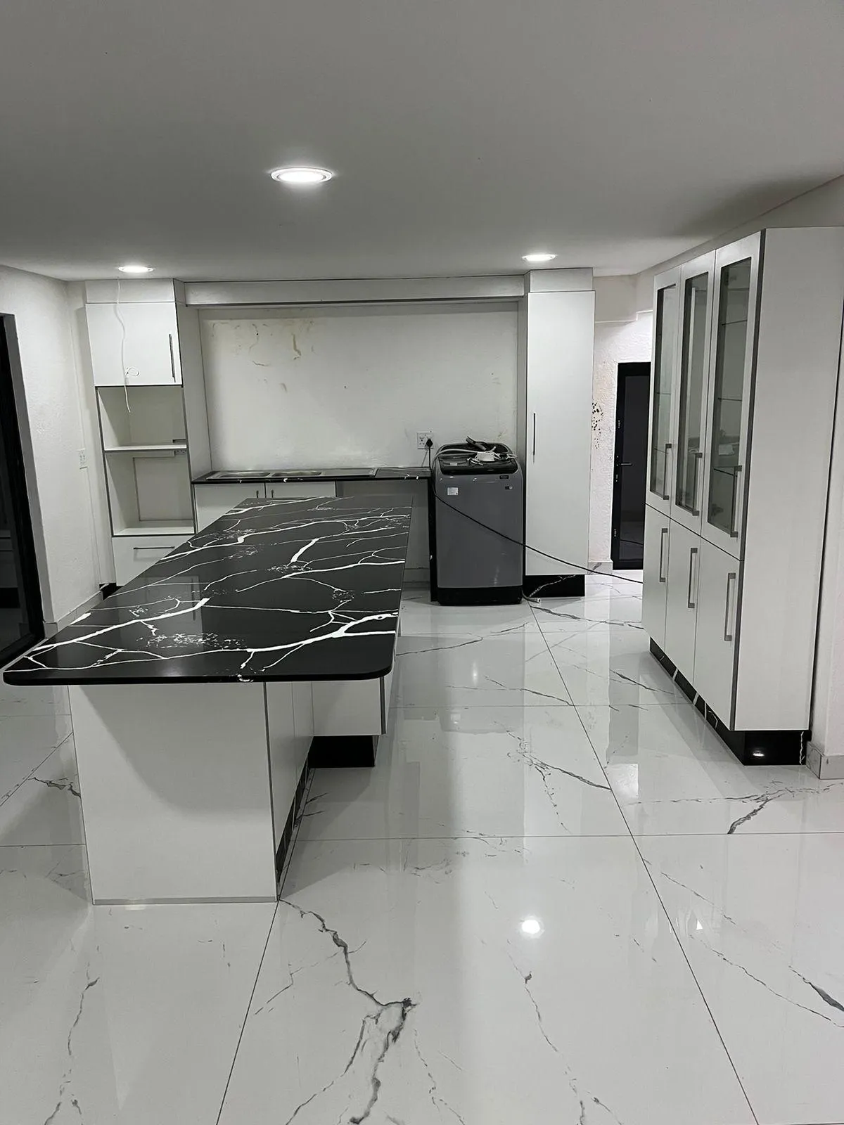 Black and white quartz countertop with white built-in cabinets, featuring a sleek and modern design.