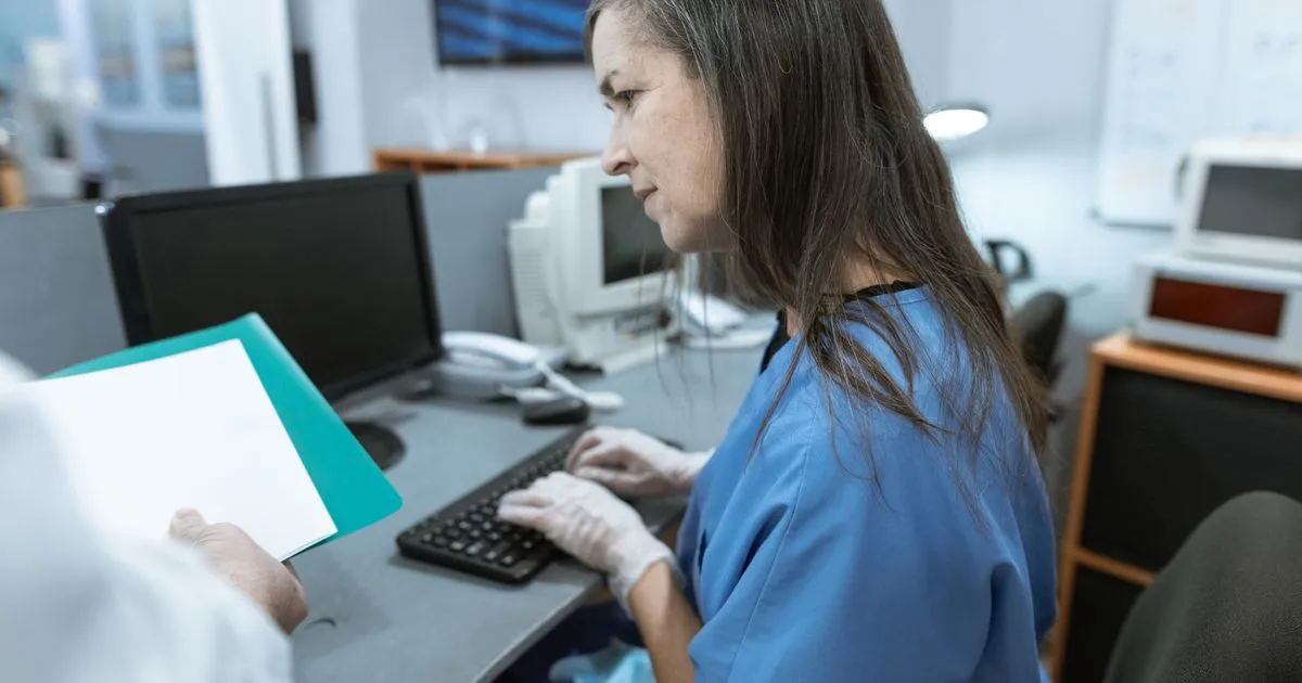 Certified medical coding specialist assigning CPT and ICD-10 codes at a workstation in a Tulsa medical billing office