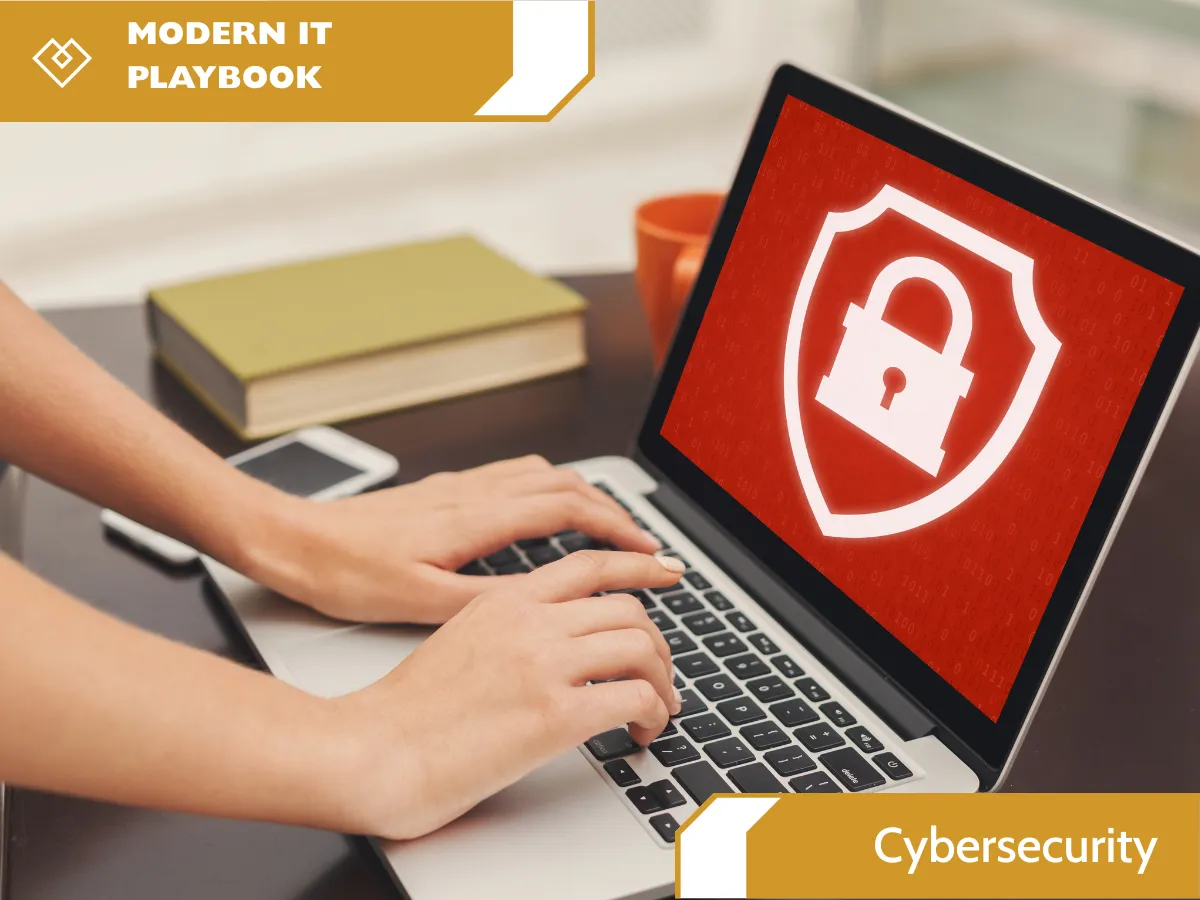 Person typing on a laptop with the title ‘Modern IT Playbook: Cybersecurity.
