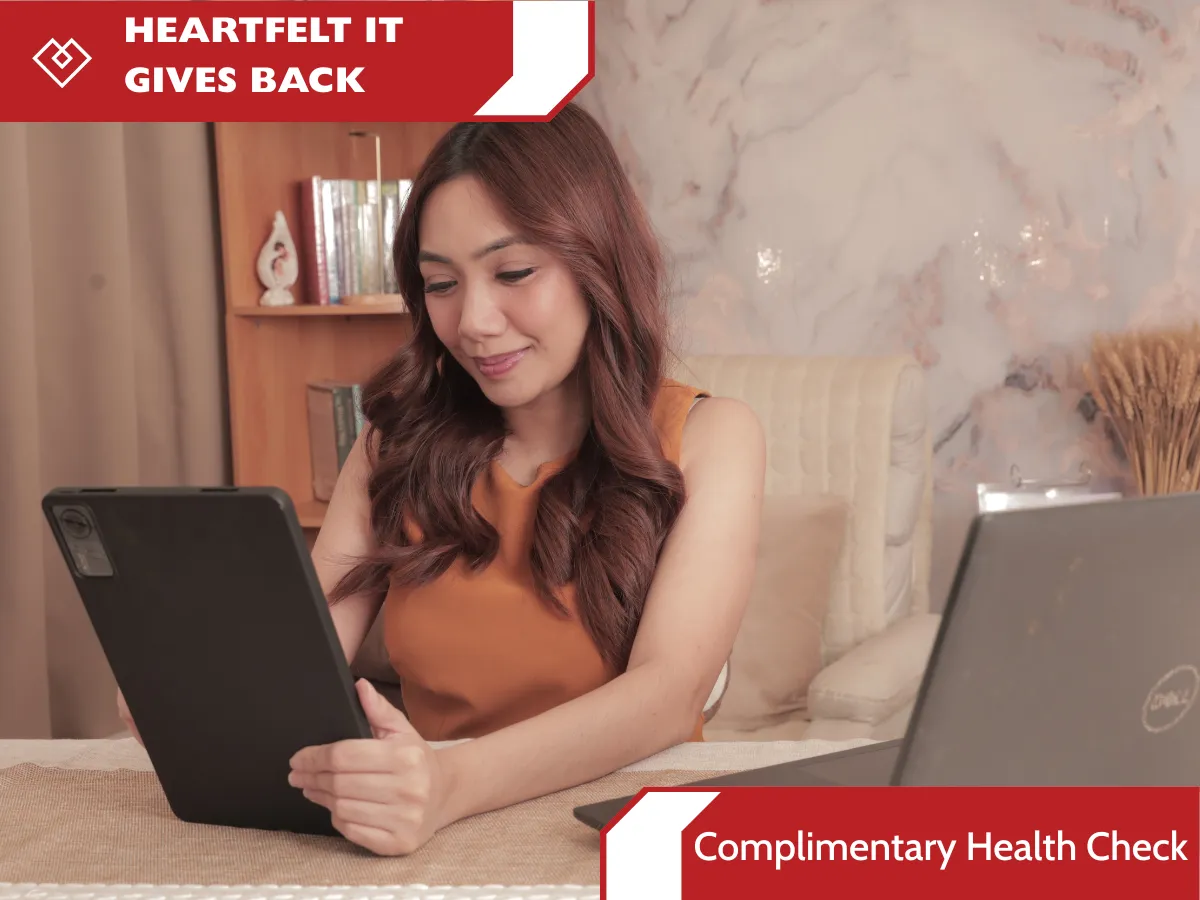 Woman using tablet and laptop for a Heartfelt IT complimentary health check