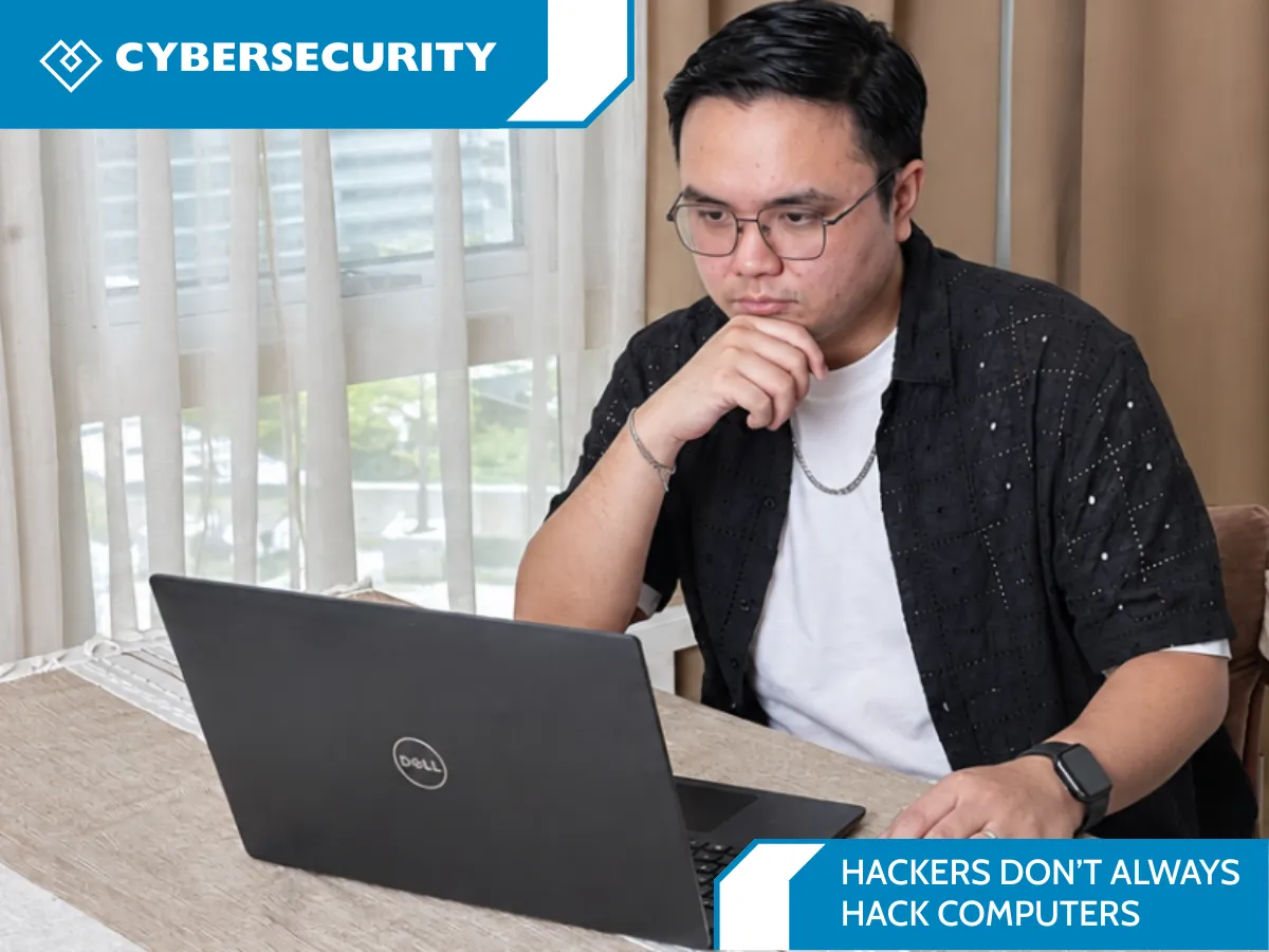 A man thoughtfully reviews his laptop beside the headline “Hackers Don’t Always Hack Computers,” illustrating how cyberattacks can target people through social engineering.