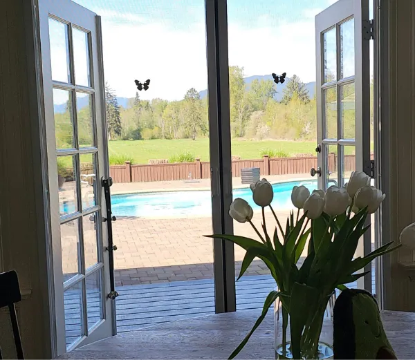 Picture of two retractable screen doors installed on french door by Screenguy Sam with his signature butterfly stickers in city of Coquitlam