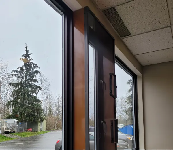 A black two handle wicket window screen installed on an office building in mission BC
