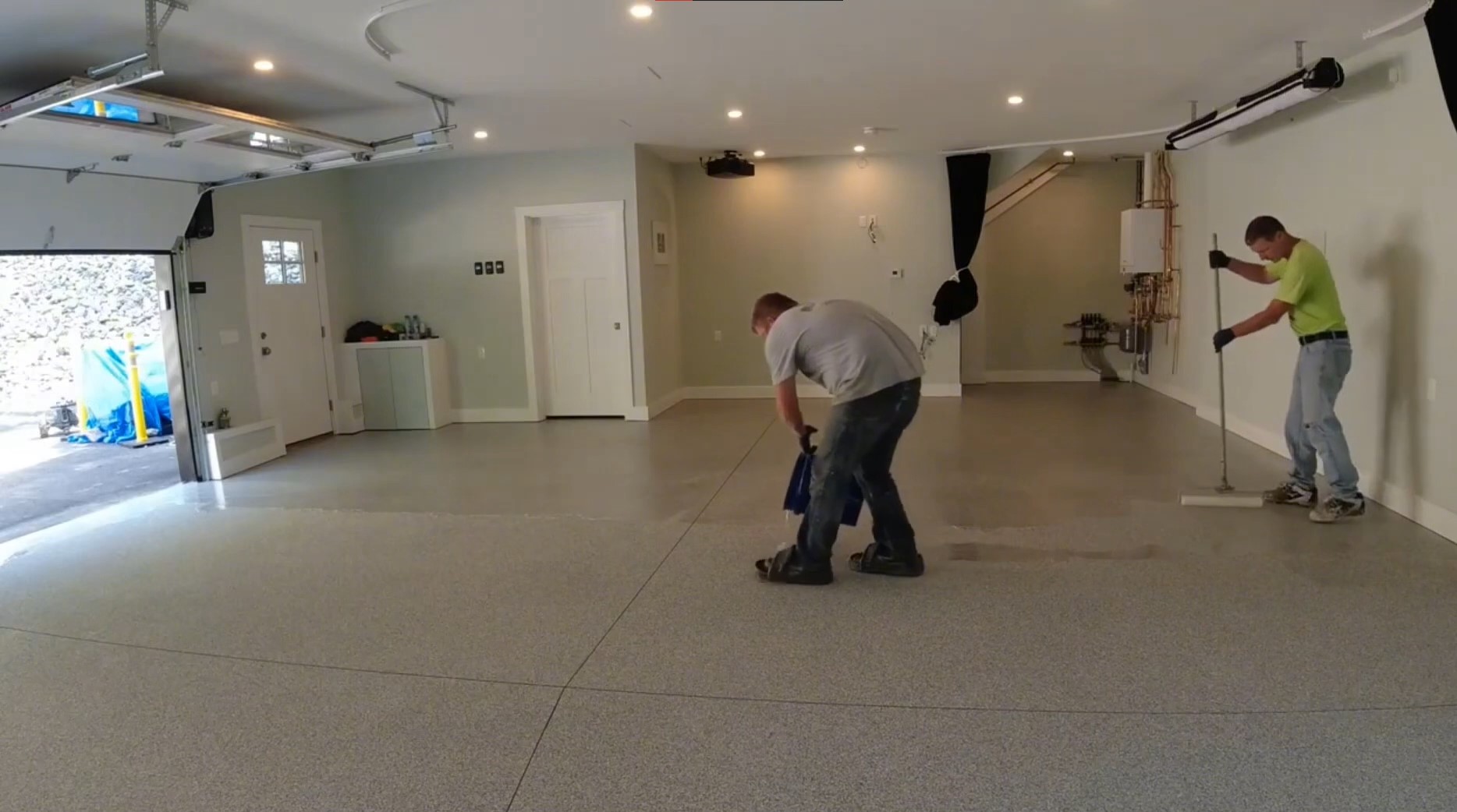 2 man applying sealant in garage before garage epoxy applied