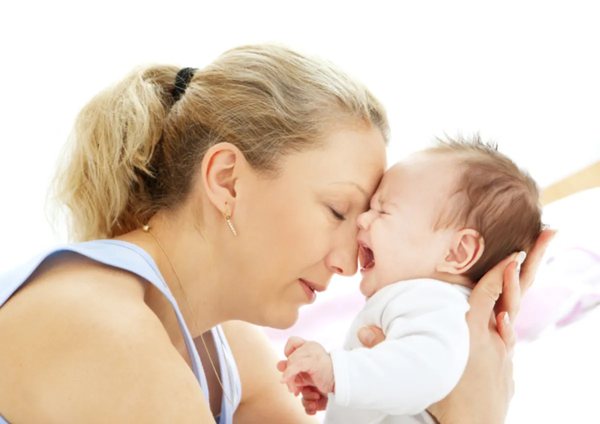 Mother holding her unsettled newborn close during a breastfeeding moment, illustrating common feeding difficulties addressed through Geraldine Miskin’s breastfeeding frameworks.