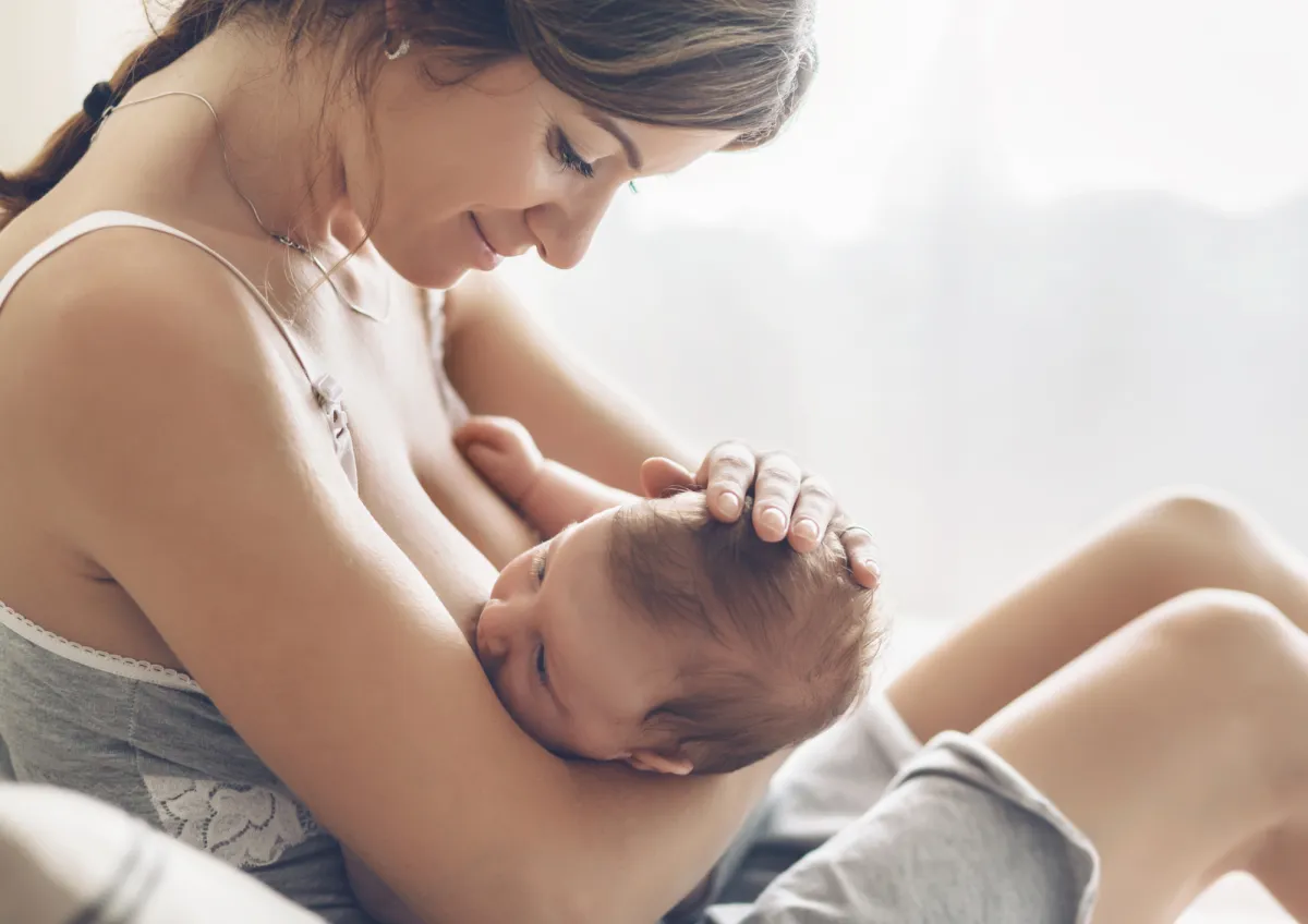 A mother breastfeeding her newborn in a calm, bright room. The baby is latched and settled, showing the goal of comfortable and effective feeding. Image used on the Personalised Feeding Review page about understanding feeding, wind and sleep challenges.