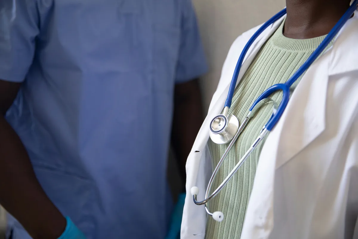 doctor using tablet exam room, physician EMR charting, doctor with technology clinic