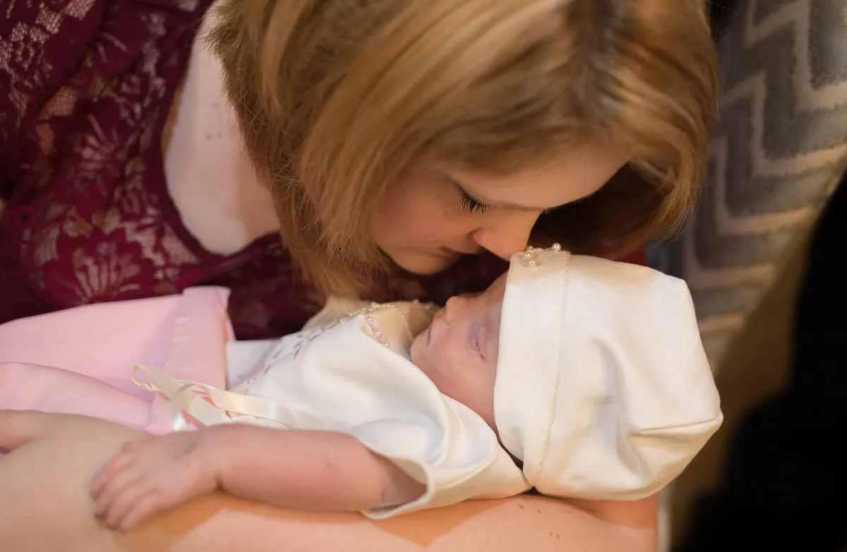 Caitlin Harris gently embracing her infant daughter Ellie, who passed away in 2017. This heartfelt moment captures the deep love and connection that inspired Caitlin to reshape her perspective and build a life centered on purpose, freedom, and helping others find clarity in their own journeys.