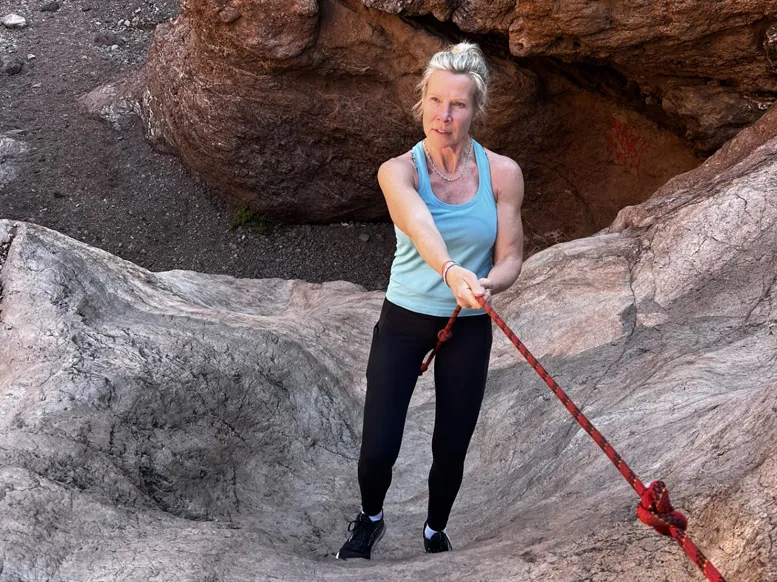 Rashelle Mason rappelling down a rock wall