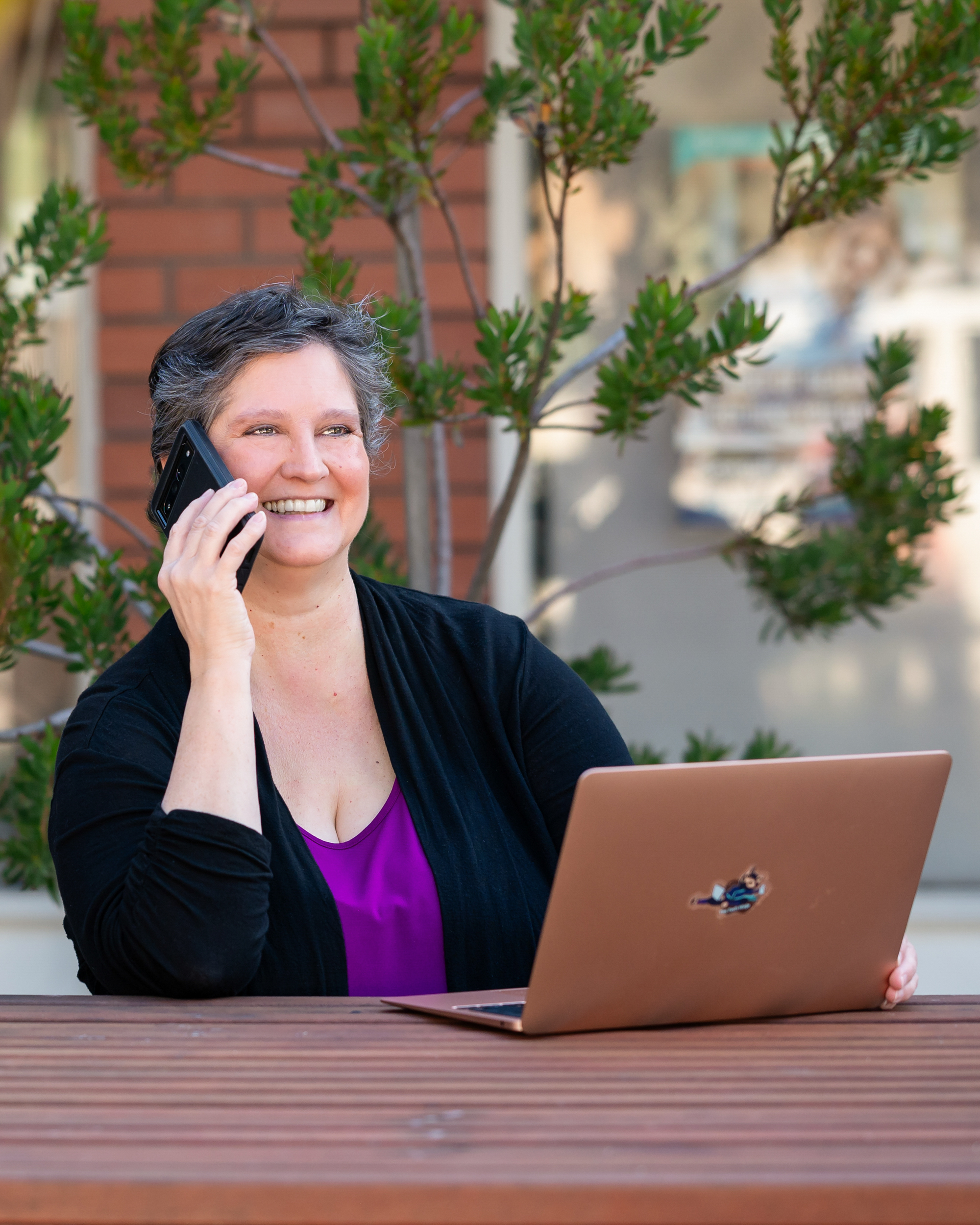 woman on phone with laptop