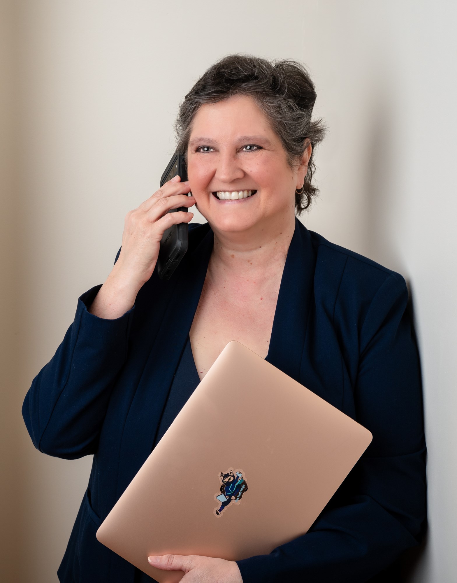 woman on phone holding laptop