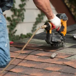 Man attaching flashing to a residential chimney rooftop