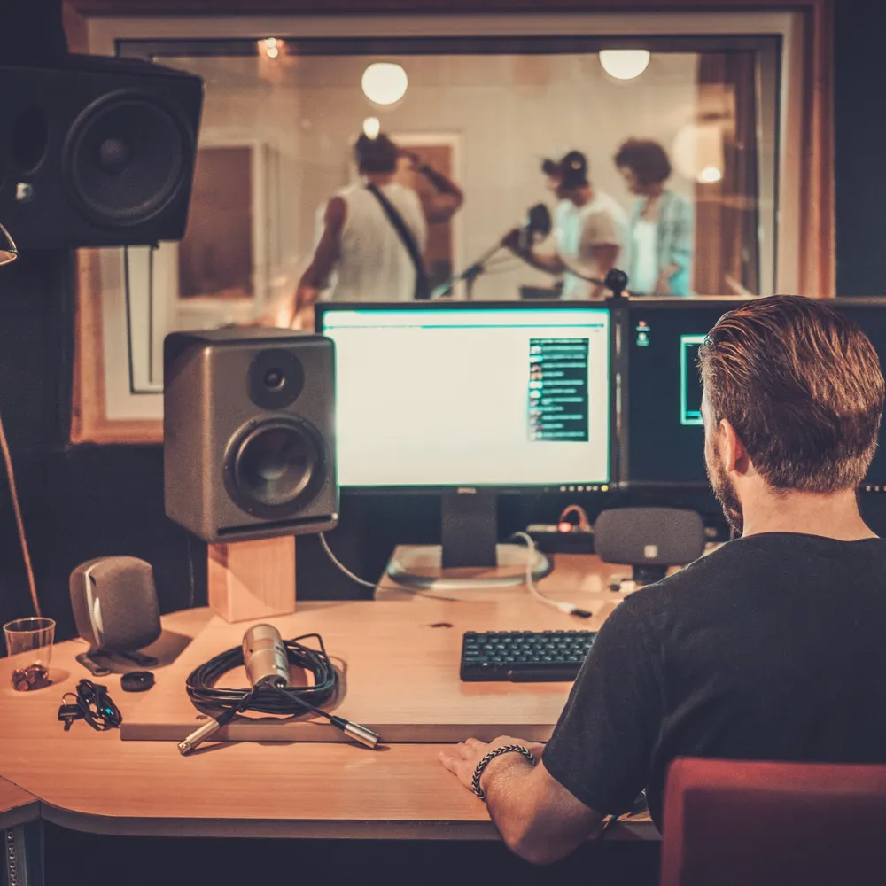 Close-up of a music producer adjusting sound levels on a digital audio mixer