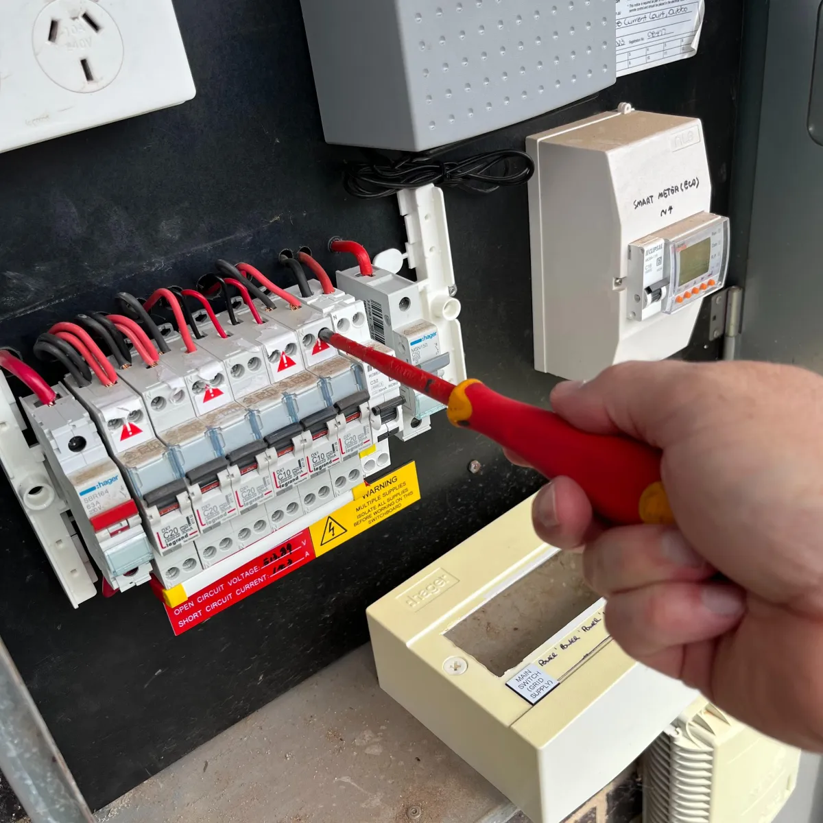 1010 Safety licensed electrician testing safety switches in a Dubbo switchboard