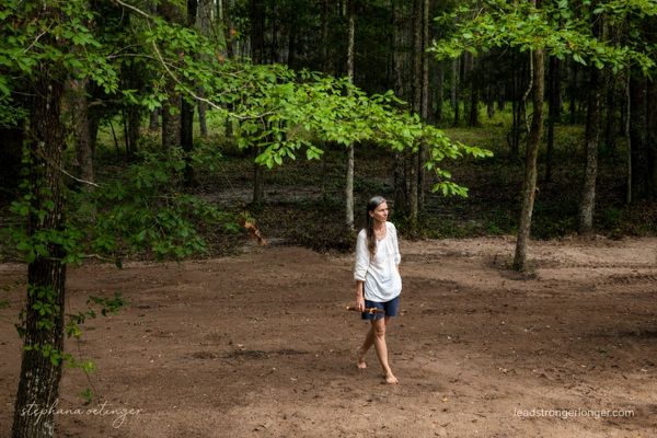 Stephana Oetinger walking her family land at sunrise, Native American flute in hand, practicing release