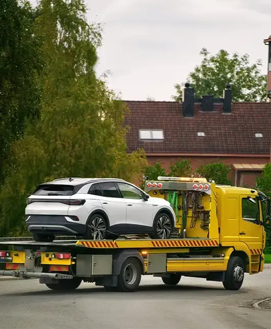Tow truck transporting SUV on flatbed providing reliable roadside towing service for stranded drivers