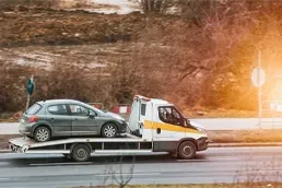 Local Distance Towing Service Transporting Car on Tow Truck Tow truck carrying disabled car on flatbed for short distance local towing service on roadside