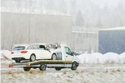 Long Distance Towing Service Transporting Vehicle on Flatbed Truck Flatbed tow truck carrying white car during long distance towing service on highway